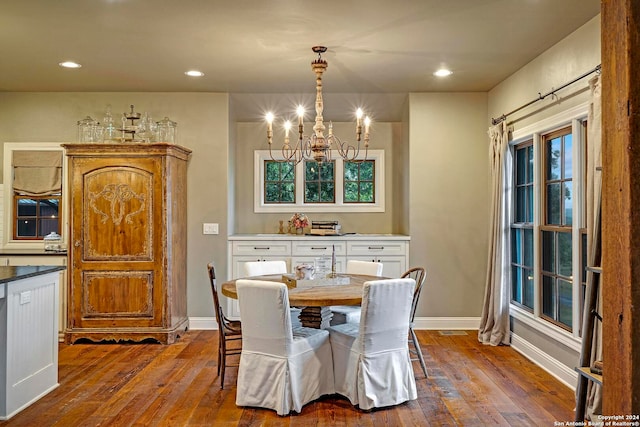 dining space featuring wood-type flooring and an inviting chandelier