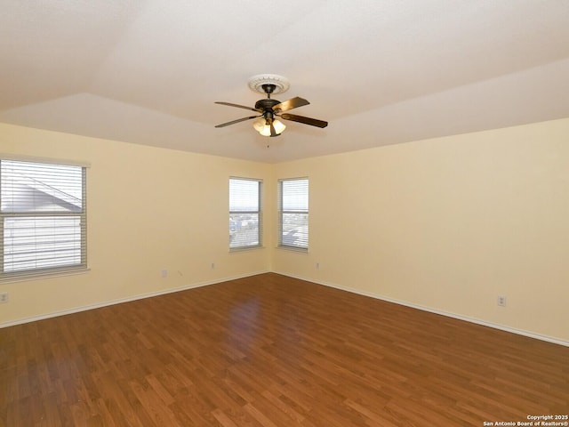 empty room featuring dark hardwood / wood-style floors, ceiling fan, and lofted ceiling