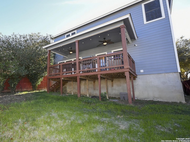 back of property featuring a lawn, a wooden deck, and ceiling fan