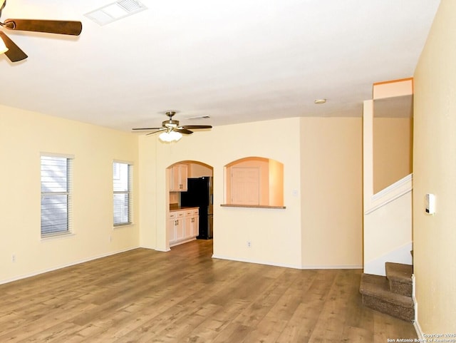 unfurnished living room featuring ceiling fan and light hardwood / wood-style floors