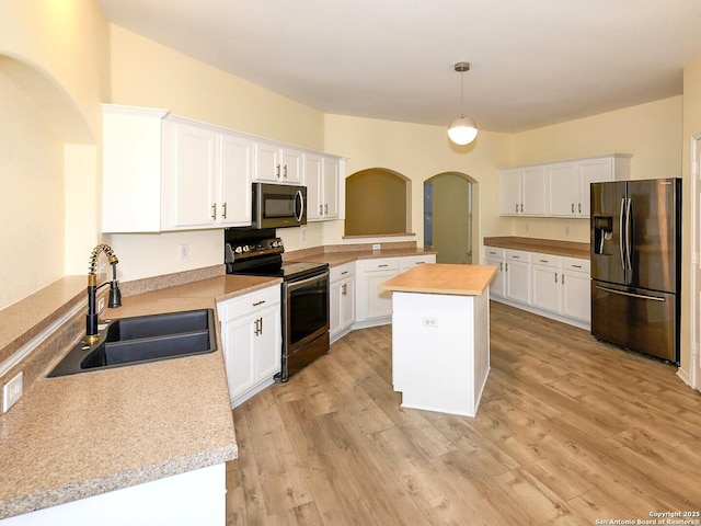 kitchen featuring stainless steel appliances, sink, pendant lighting, white cabinets, and a center island