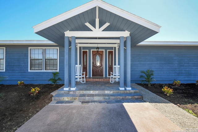 view of exterior entry with a porch