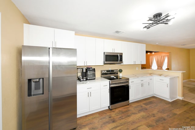 kitchen featuring light stone counters, white cabinetry, appliances with stainless steel finishes, dark hardwood / wood-style floors, and kitchen peninsula