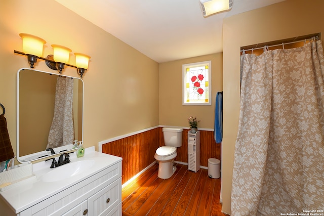 bathroom with wood walls, hardwood / wood-style floors, and vanity