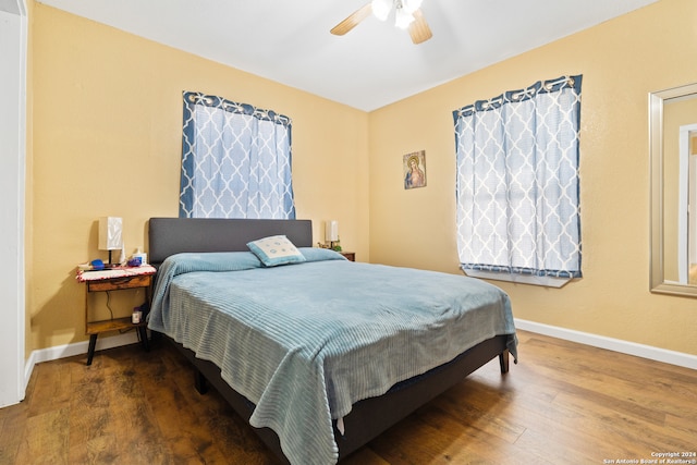 bedroom with dark hardwood / wood-style floors and ceiling fan