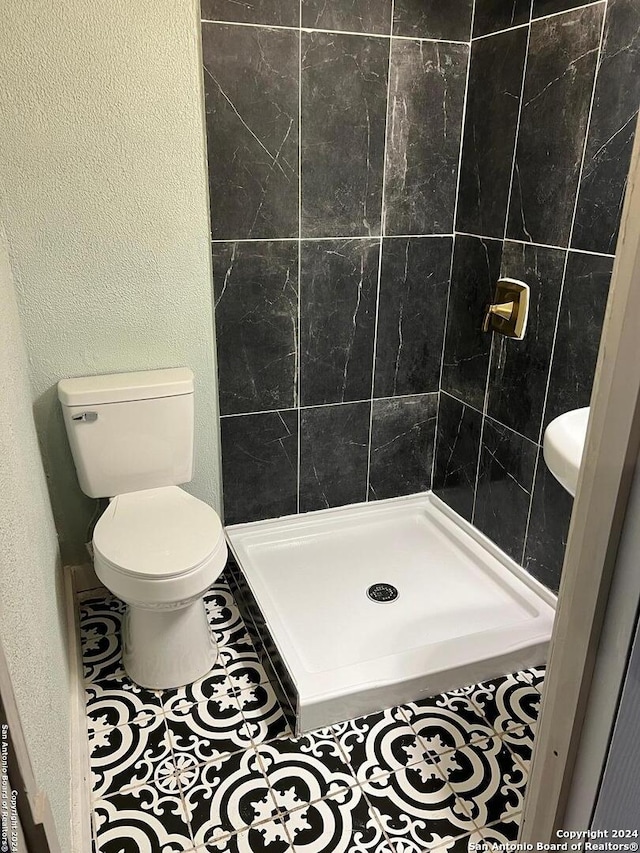 355 Mountain Creek Rd, Pipe Creek, TX 78063 - full bathroom with toilet, a shower stall, tile patterned flooring, and a textured wall