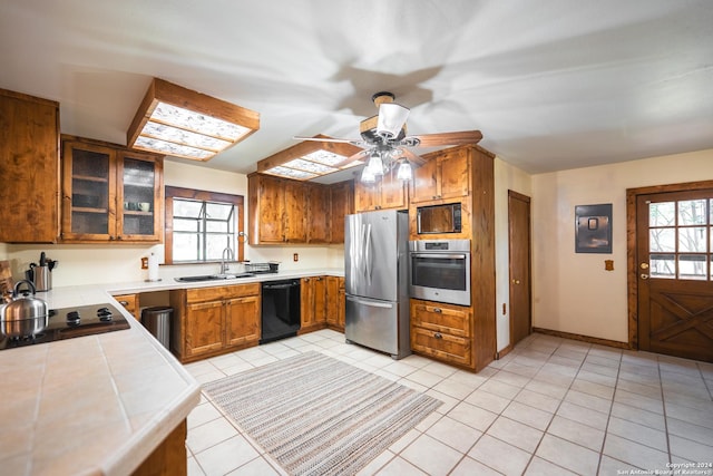 355 Mountain Creek Rd, Pipe Creek, TX 78063 - kitchen featuring black appliances, tile counters, a sink, brown cabinets, and ceiling fan