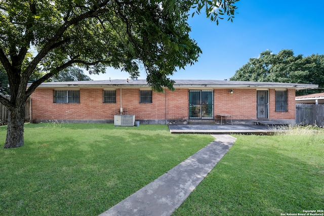 rear view of property featuring a lawn, central air condition unit, and a patio area