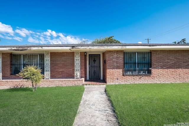 single story home featuring a front lawn