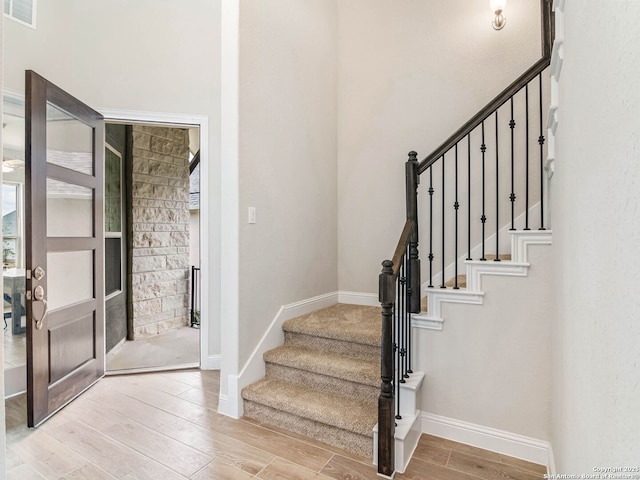 office space featuring a ceiling fan, baseboards, and light wood-type flooring