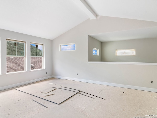 empty room with lofted ceiling with beams