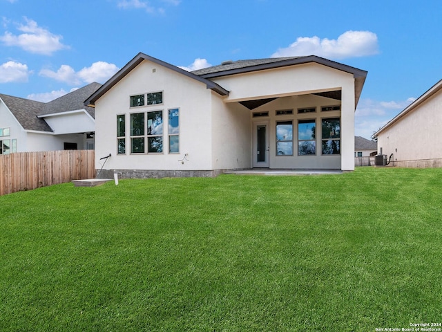 back of house with a lawn, a patio area, and central AC