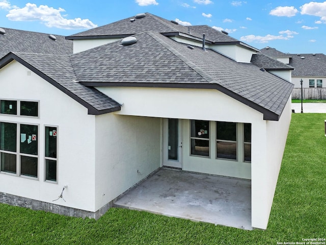 rear view of house with a yard and a patio area