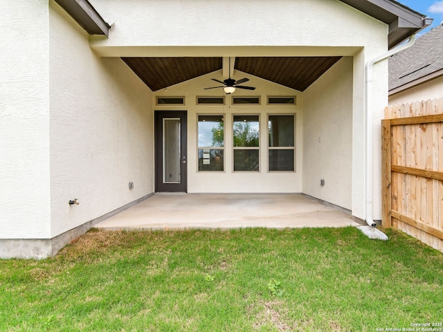 back of house with a lawn, a shingled roof, a patio area, and stucco siding