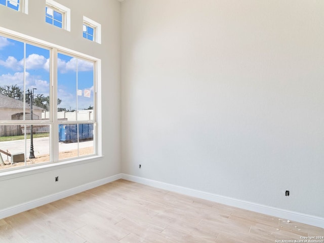 spare room featuring light wood-type flooring and plenty of natural light