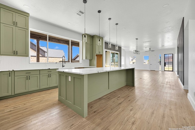 kitchen with green cabinets, a center island, and a healthy amount of sunlight