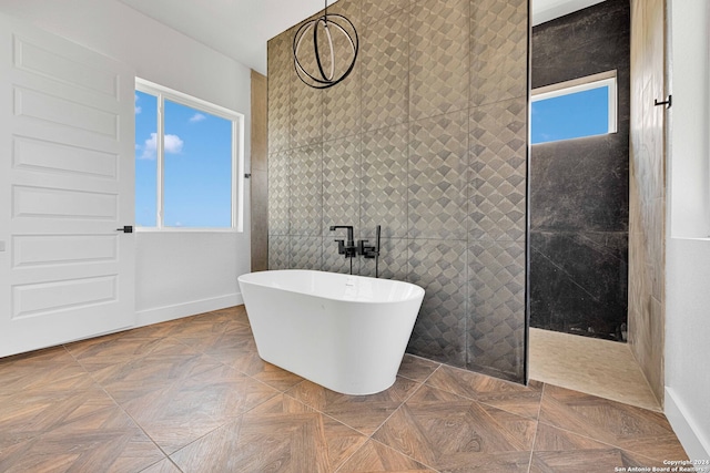 bathroom featuring independent shower and bath, tile walls, parquet floors, and a wealth of natural light