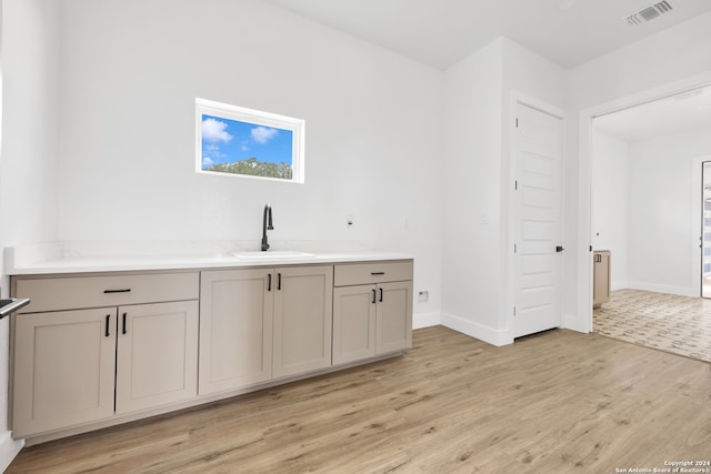 bar featuring light hardwood / wood-style flooring and sink