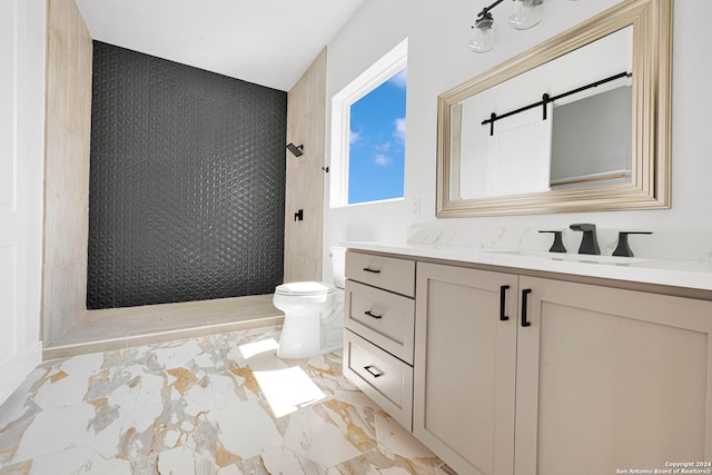 bathroom with vanity, toilet, and tiled shower