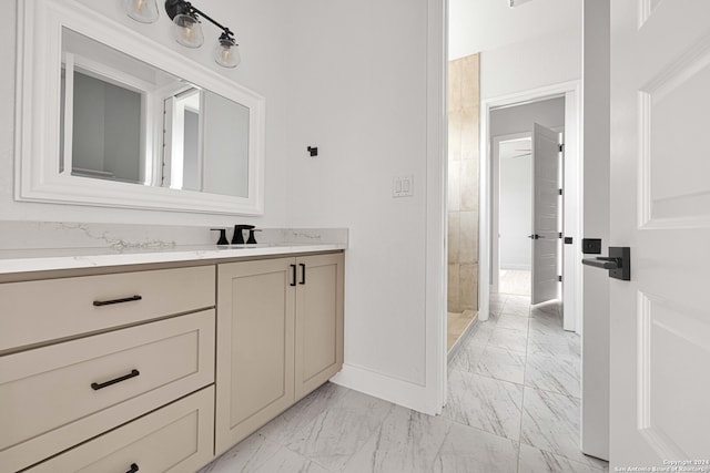 bathroom featuring a tile shower and vanity