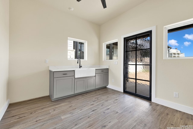 interior space with gray cabinetry, light wood-type flooring, ceiling fan, and sink