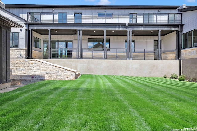 rear view of house featuring a yard