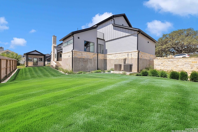 back of property with a lawn and central air condition unit