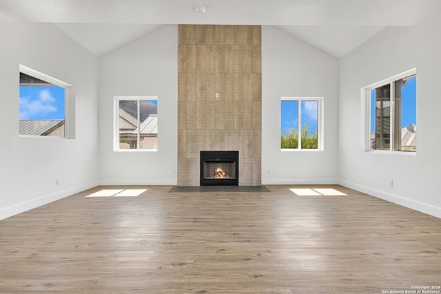 unfurnished living room with light hardwood / wood-style floors, lofted ceiling, and a fireplace