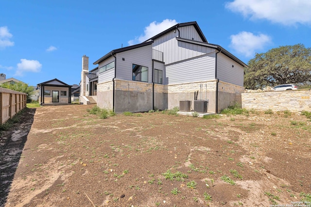 rear view of house featuring central air condition unit