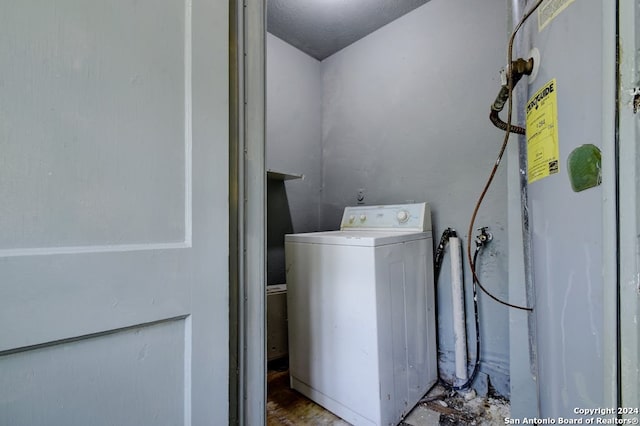 clothes washing area featuring water heater and washer / clothes dryer