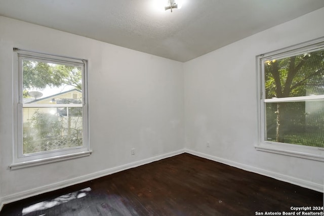 unfurnished room with hardwood / wood-style floors and a healthy amount of sunlight