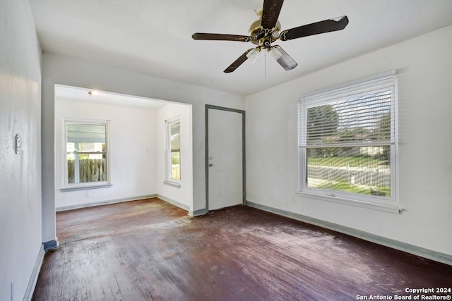 unfurnished bedroom featuring multiple windows, ceiling fan, and dark hardwood / wood-style flooring