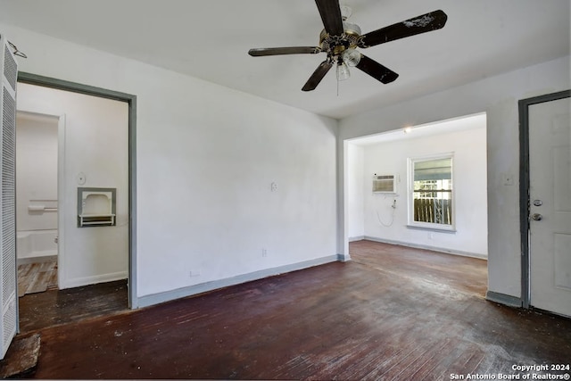 spare room featuring ceiling fan, dark wood-type flooring, and an AC wall unit