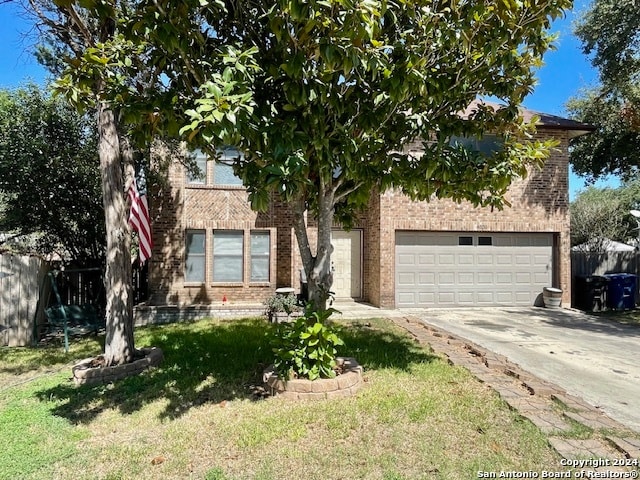 obstructed view of property with driveway, an attached garage, fence, a front lawn, and brick siding