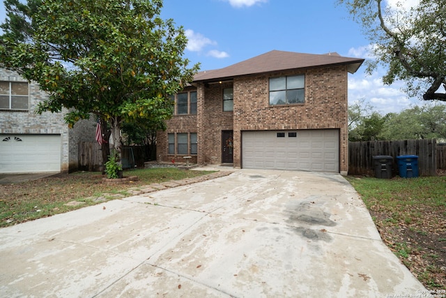 traditional-style home with brick siding, fence, a garage, and concrete driveway