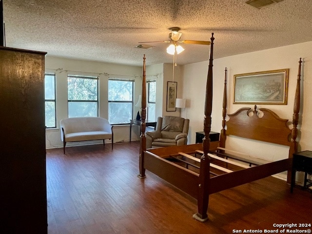 bedroom featuring visible vents, a textured ceiling, and wood finished floors