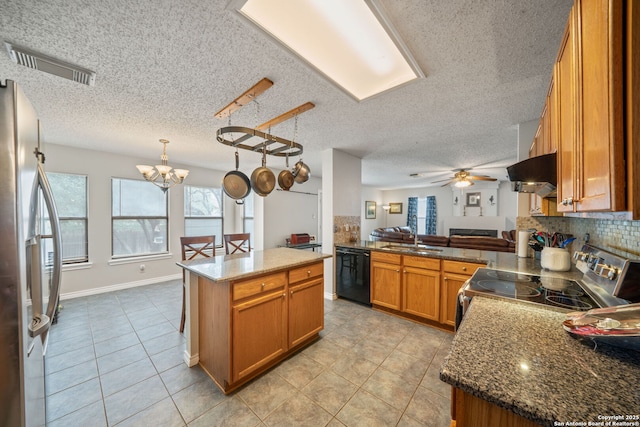 kitchen with under cabinet range hood, visible vents, brown cabinets, appliances with stainless steel finishes, and a sink