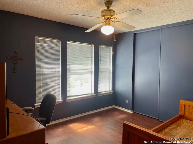 office area featuring ceiling fan, a textured ceiling, baseboards, and wood finished floors