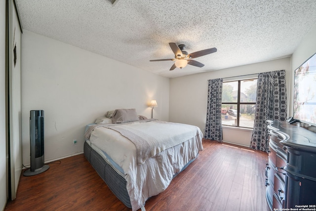 bedroom featuring a textured ceiling, a ceiling fan, and wood finished floors