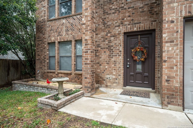 property entrance with brick siding and fence