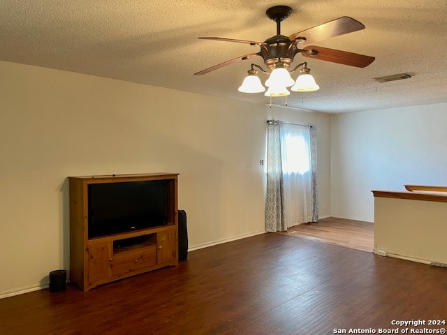 unfurnished living room featuring a textured ceiling, ceiling fan, wood finished floors, and visible vents