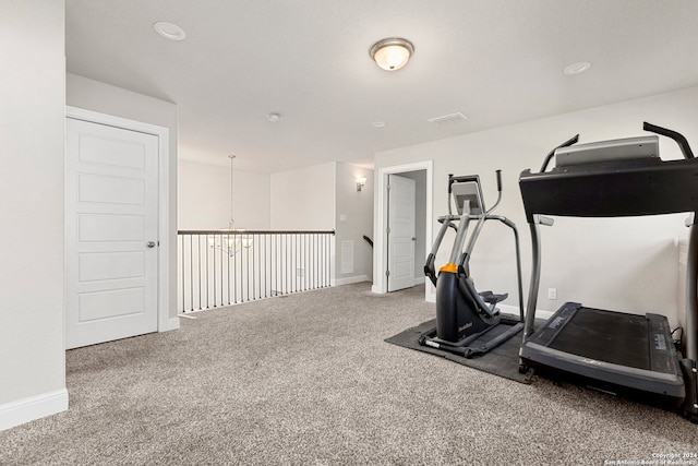 workout room with carpet floors and an inviting chandelier