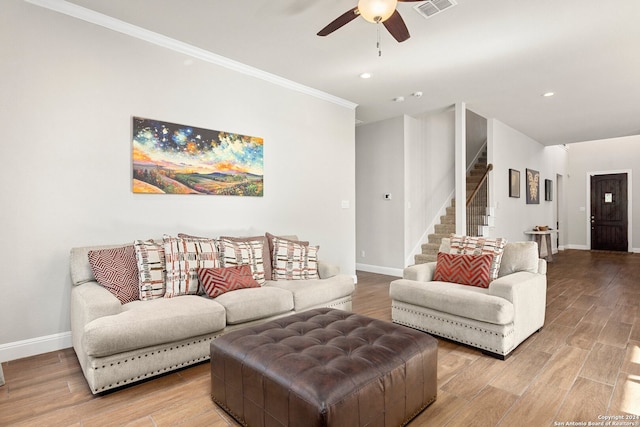 living room with light wood-type flooring, ornamental molding, and ceiling fan