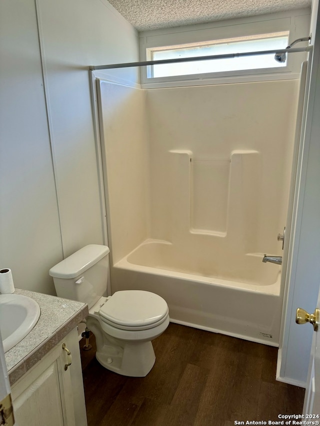 full bathroom with vanity, a textured ceiling, shower / bathing tub combination, hardwood / wood-style flooring, and toilet