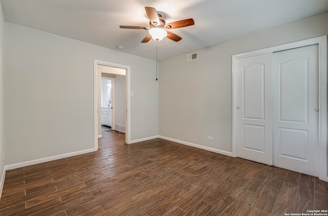 unfurnished bedroom with a closet, ceiling fan, and dark wood-type flooring