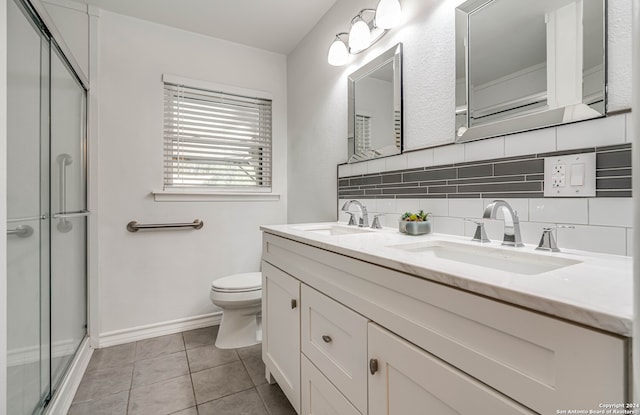 bathroom with vanity, toilet, walk in shower, tile patterned flooring, and decorative backsplash