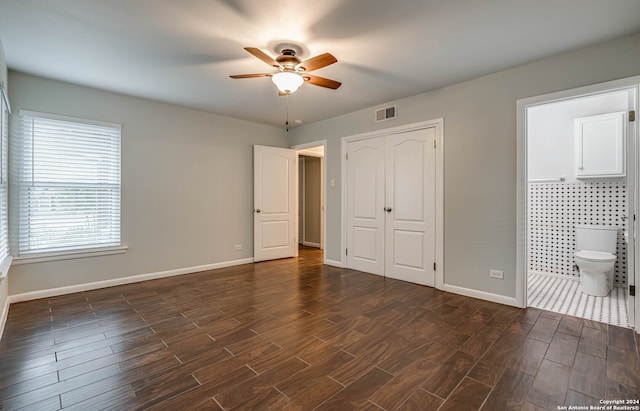 unfurnished bedroom featuring a closet, ceiling fan, dark hardwood / wood-style floors, and ensuite bathroom