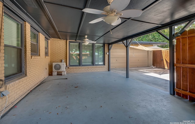 view of patio featuring a garage, ceiling fan, an outbuilding, and ac unit