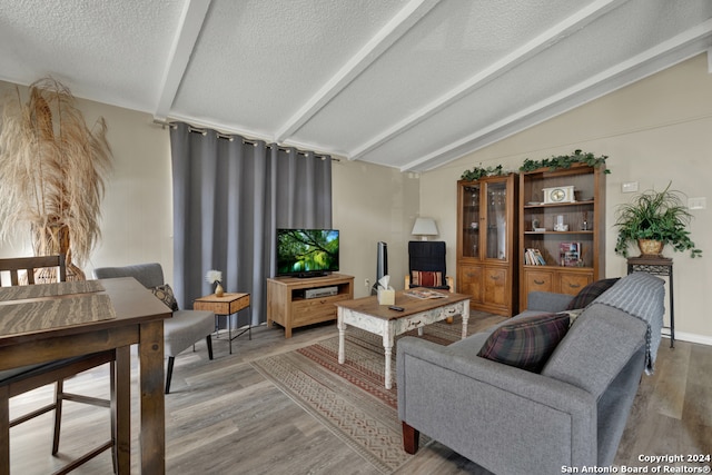 living room with vaulted ceiling with beams and hardwood / wood-style floors