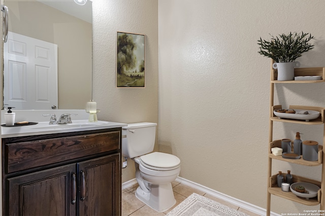 bathroom with toilet, tile patterned flooring, baseboards, and vanity